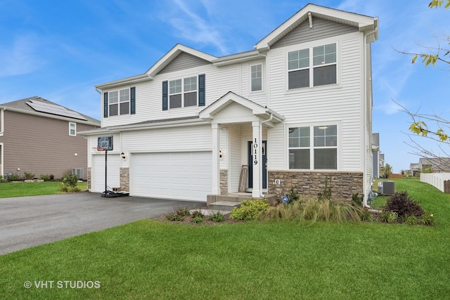 view of front of home featuring a garage, a front yard, and central AC