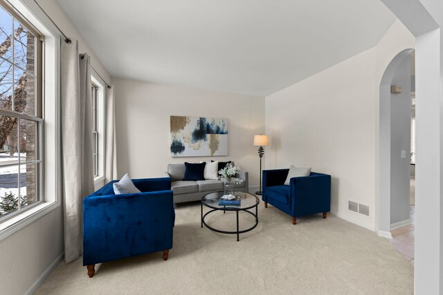 dining space featuring light carpet, a wealth of natural light, and an inviting chandelier