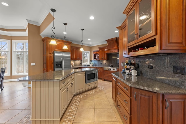 kitchen with a kitchen island, decorative light fixtures, light tile patterned floors, stainless steel appliances, and custom range hood