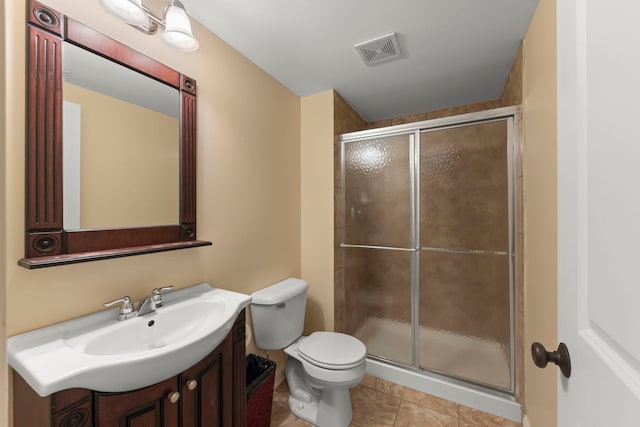 bathroom featuring vanity, toilet, tile patterned flooring, and a shower with door