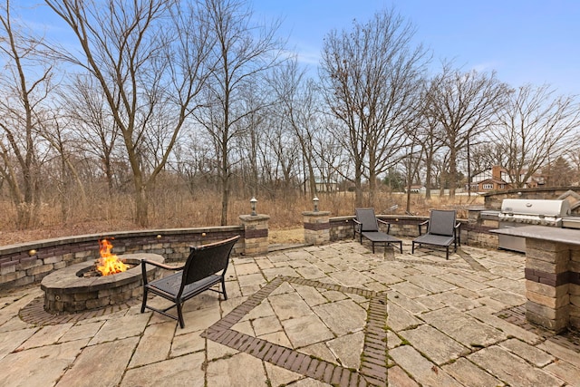 view of patio / terrace with an outdoor kitchen, grilling area, and an outdoor fire pit