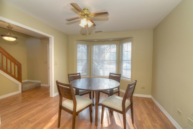 dining area with ceiling fan and light hardwood / wood-style floors