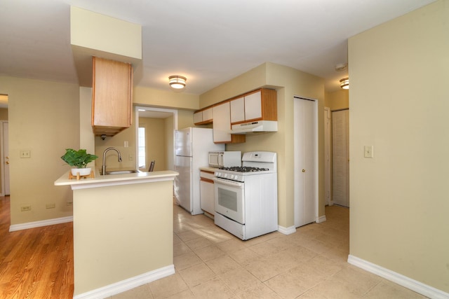 kitchen featuring sink, white appliances, and kitchen peninsula