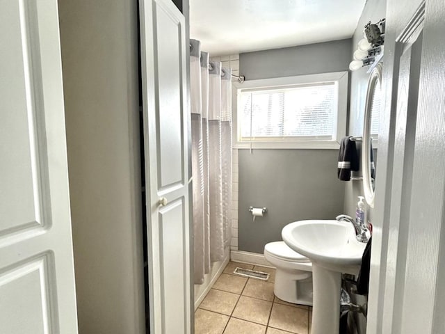 bathroom featuring tile patterned floors, shower / bath combination with curtain, and toilet