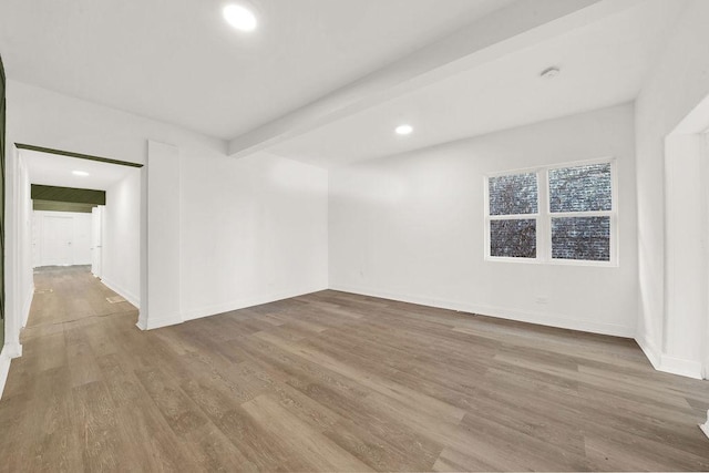 unfurnished room featuring beamed ceiling and wood-type flooring