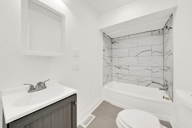 full bathroom with tiled shower / bath, vanity, and toilet