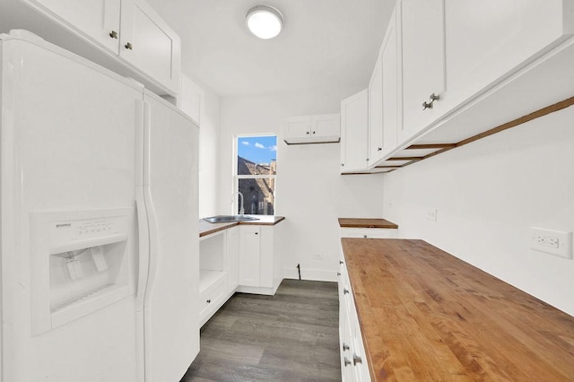 kitchen featuring butcher block counters, sink, white cabinets, white refrigerator with ice dispenser, and dark wood-type flooring