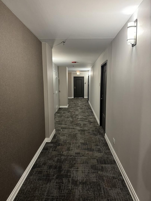 hallway featuring dark colored carpet