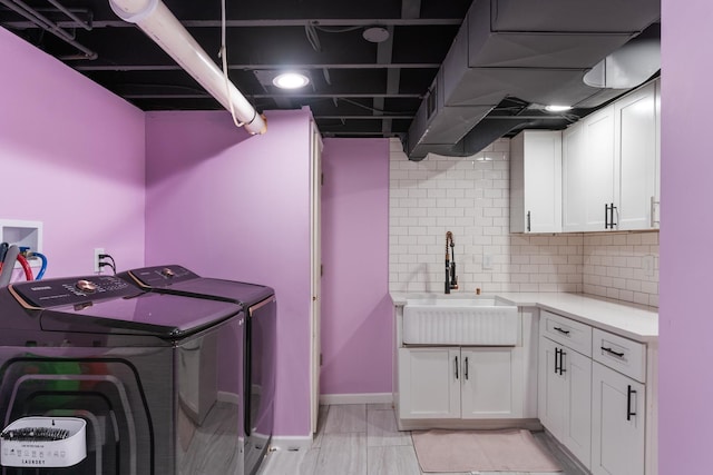 washroom featuring cabinets, independent washer and dryer, and sink