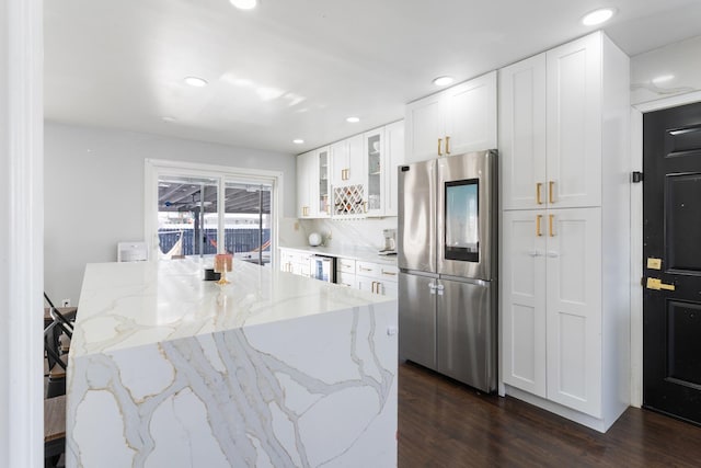 kitchen featuring white cabinets, dark hardwood / wood-style floors, stainless steel fridge, light stone countertops, and beverage cooler