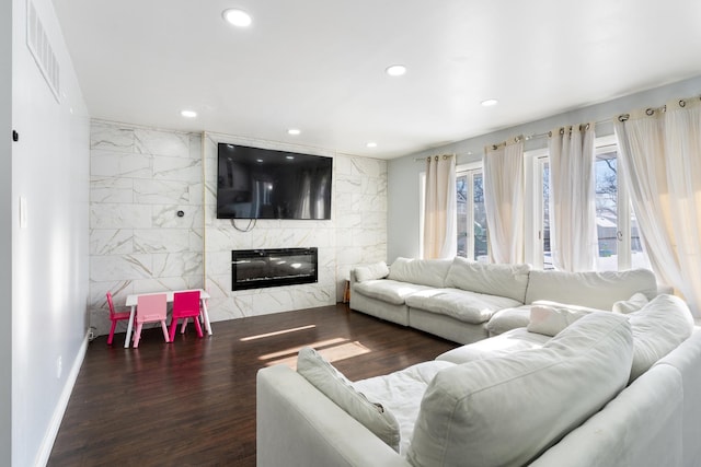 living room with a fireplace, dark hardwood / wood-style floors, and tile walls