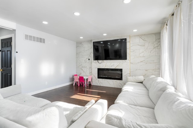 living room with a fireplace, tile walls, and dark wood-type flooring