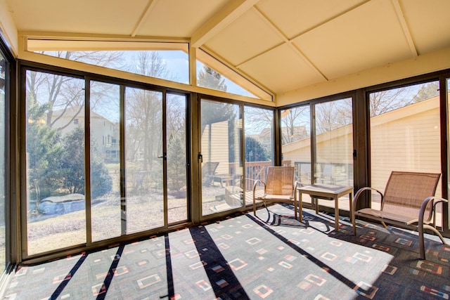 unfurnished sunroom with vaulted ceiling with beams