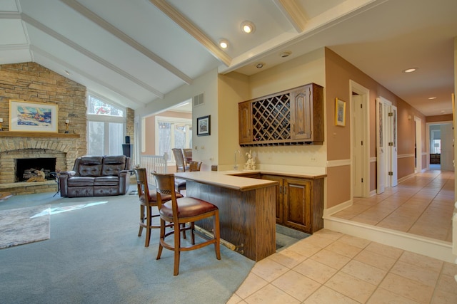 bar featuring visible vents, lofted ceiling with beams, a large fireplace, light tile patterned flooring, and indoor wet bar