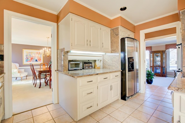 kitchen featuring light tile patterned flooring, stainless steel fridge with ice dispenser, white cabinetry, crown molding, and a notable chandelier