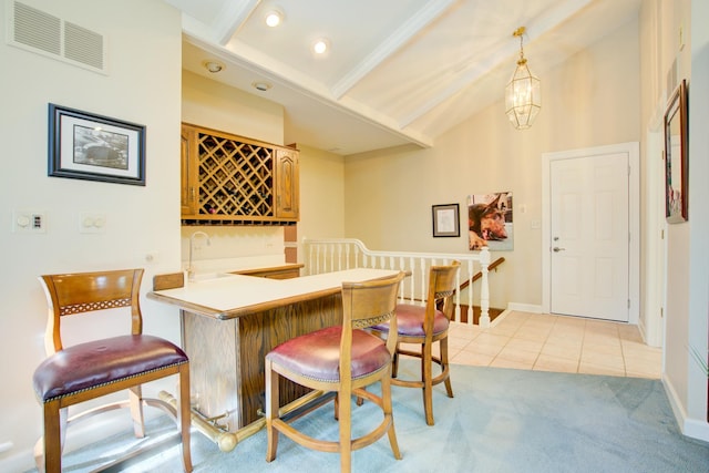 dining area featuring visible vents, baseboards, lofted ceiling with beams, indoor wet bar, and light tile patterned flooring