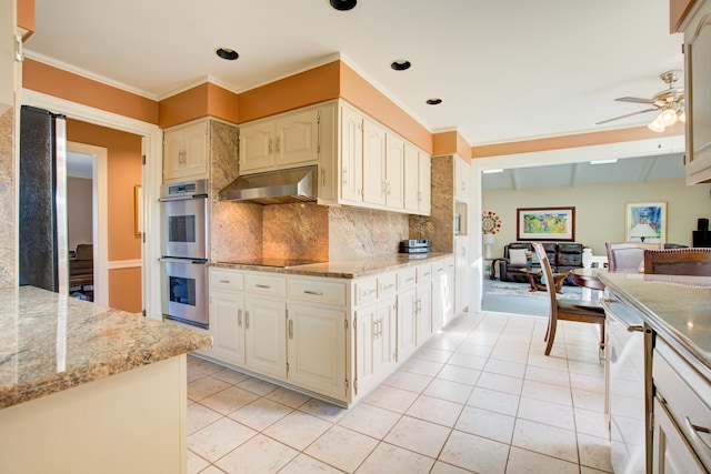 kitchen featuring black electric stovetop, under cabinet range hood, double oven, light tile patterned floors, and a ceiling fan