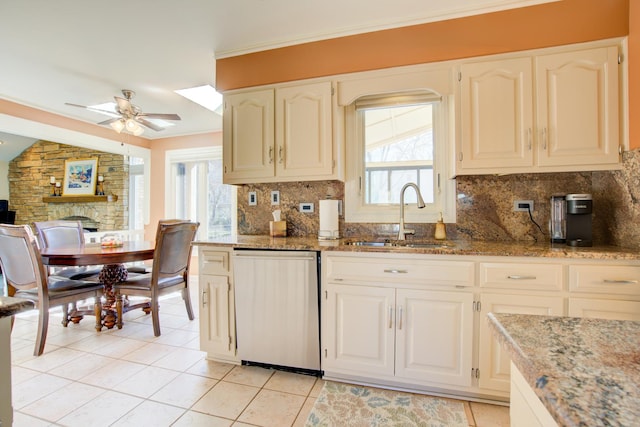 kitchen featuring a sink, ceiling fan, decorative backsplash, stone countertops, and stainless steel dishwasher