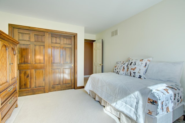 bedroom featuring baseboards, visible vents, a closet, and light carpet