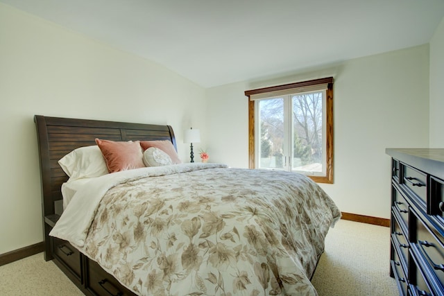 bedroom with lofted ceiling and baseboards