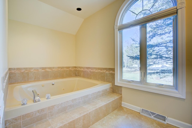 bathroom featuring visible vents, a jetted tub, tile patterned flooring, baseboards, and vaulted ceiling