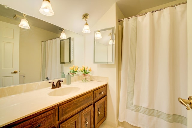 full bathroom with lofted ceiling and vanity