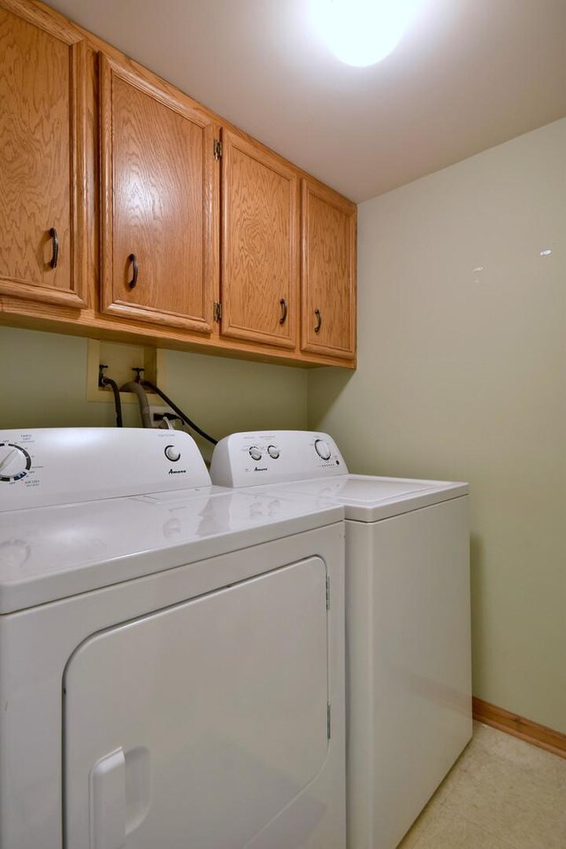 laundry area with cabinets and washing machine and dryer