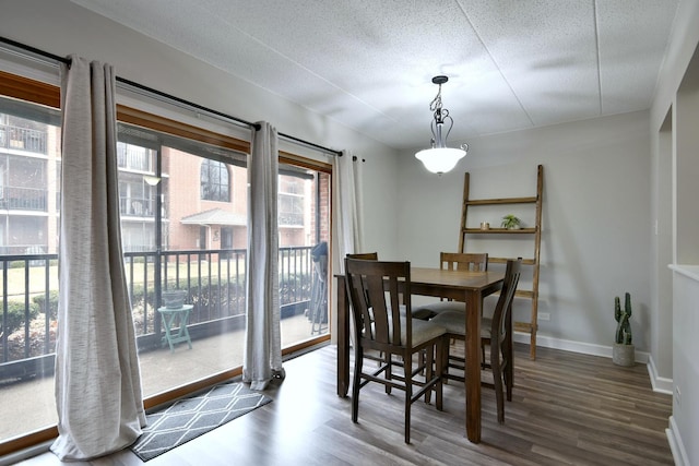 dining area with dark wood-type flooring and a textured ceiling