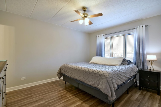 bedroom featuring a textured ceiling, dark hardwood / wood-style floors, and ceiling fan