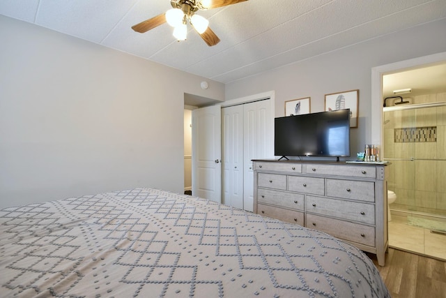 bedroom with hardwood / wood-style flooring, ensuite bathroom, ceiling fan, and a closet