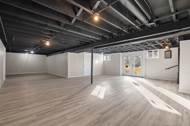 basement with french doors and hardwood / wood-style flooring