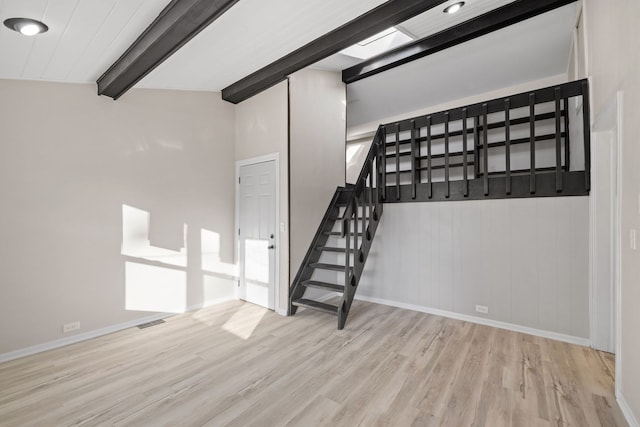 interior space with hardwood / wood-style flooring and vaulted ceiling with beams