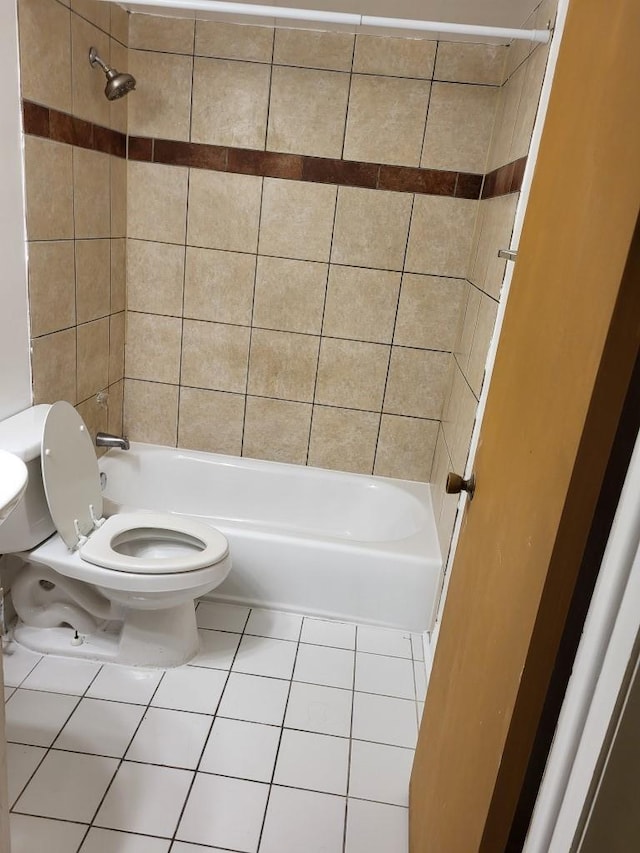 bathroom with tile patterned flooring, toilet, and tiled shower / bath