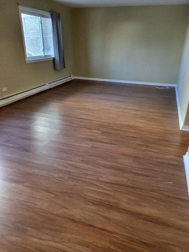 unfurnished room featuring dark hardwood / wood-style flooring and a baseboard radiator