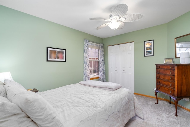 carpeted bedroom with ceiling fan and a closet