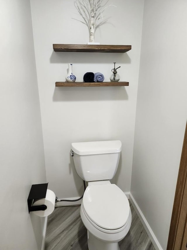 bathroom featuring wood-type flooring and toilet