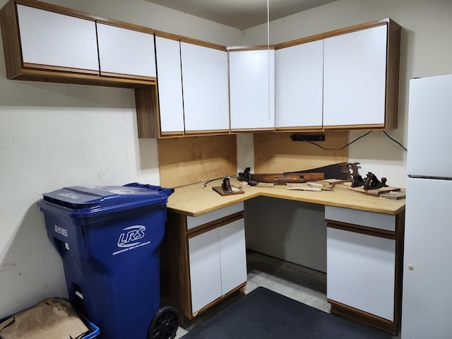 kitchen with white refrigerator and white cabinetry