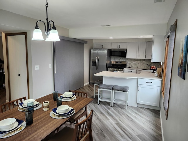 dining room featuring sink and light hardwood / wood-style floors