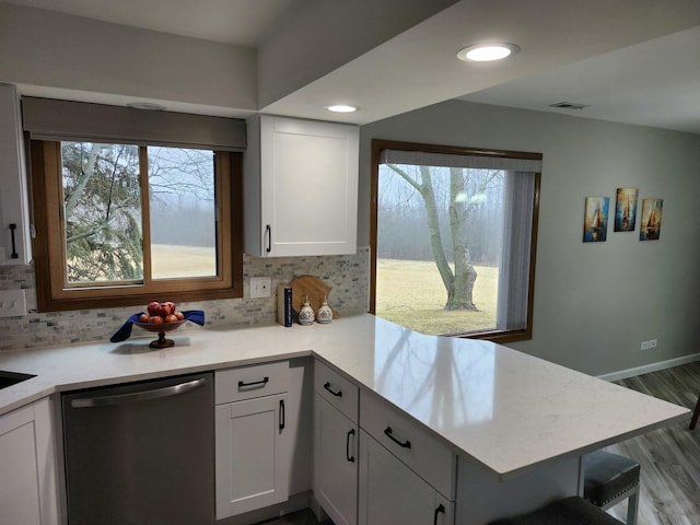 kitchen with dishwasher, backsplash, light hardwood / wood-style floors, white cabinets, and kitchen peninsula