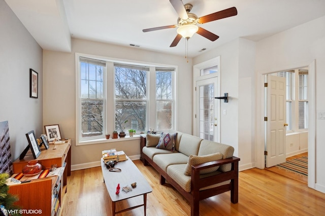 living room featuring ceiling fan and light hardwood / wood-style floors