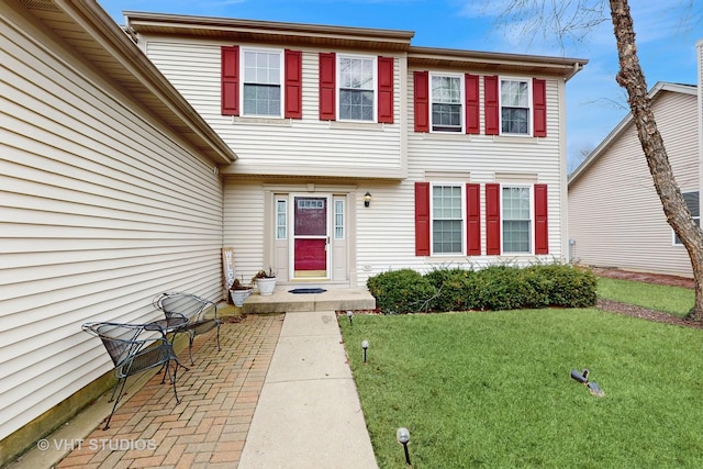 doorway to property with a lawn