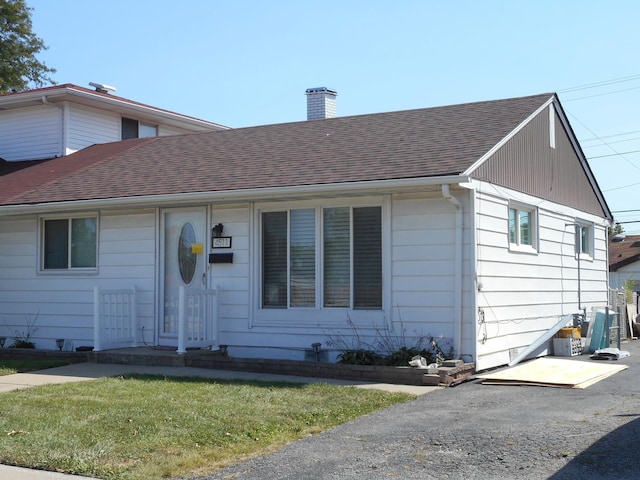 single story home featuring a front lawn