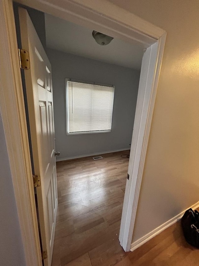 corridor with hardwood / wood-style flooring