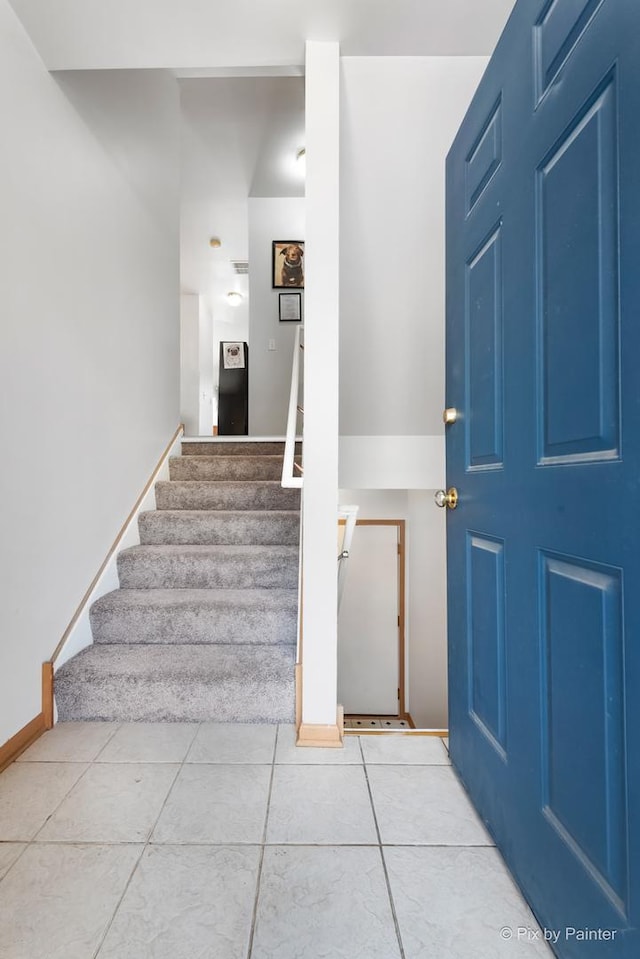 stairway featuring tile patterned flooring