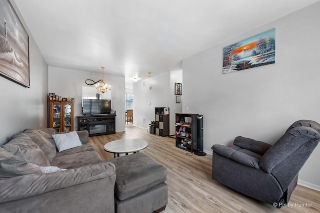 living room with a chandelier and light hardwood / wood-style flooring