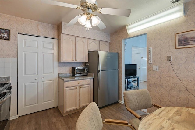 kitchen featuring light wood-type flooring, ceiling fan, and appliances with stainless steel finishes