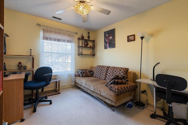 carpeted office featuring a textured ceiling and ceiling fan