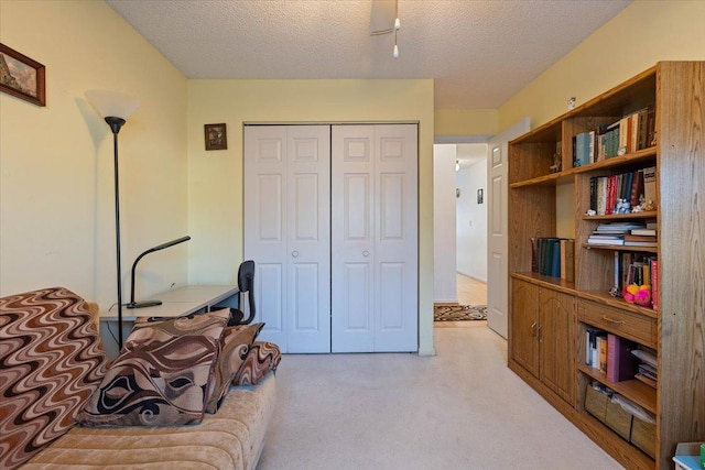 living area featuring light carpet and a textured ceiling