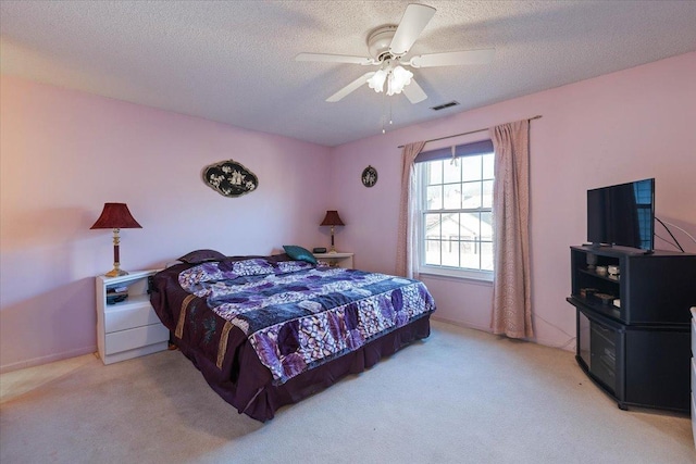 carpeted bedroom with a textured ceiling and ceiling fan