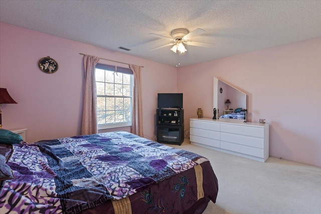 bedroom featuring ceiling fan, carpet, and a textured ceiling